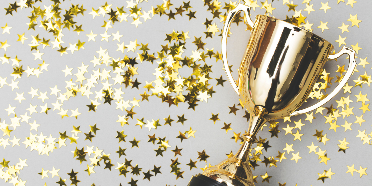 A trophy surrounded by star shaped confetti.