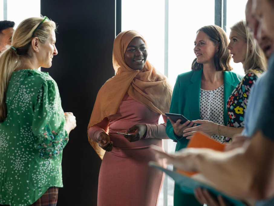 A group of people chat happily. 